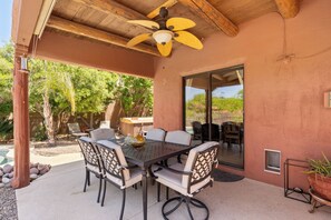 Covered patio, outdoor dining table & comfortable chairs, ceiling fan 
& light