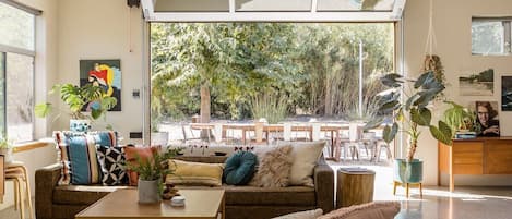 Roll up glass garage door in living room that connects blends inside/outside spaces.  