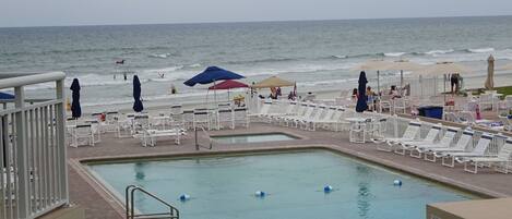 Close up view from apartment balcony of pool deck and ocean. 