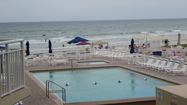 Close up view from apartment balcony of pool deck and ocean. 