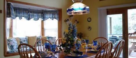 Dining room overlooking window seat with sliding doors to deck and extra seating