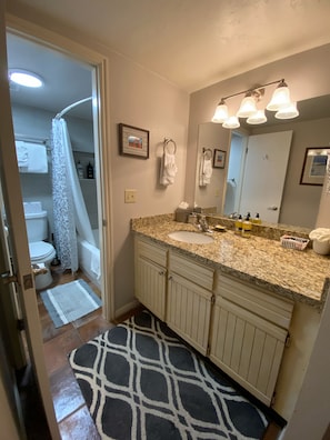 Second Bathroom w/large granite vanity sink & new remodeled bathtub/shower room.