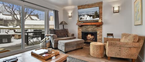 Comfortable seating, TV and stacked stone, gas fireplace in the living area.