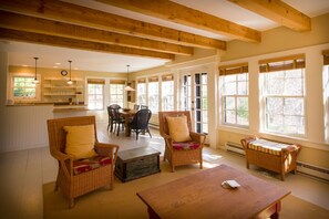 Window-lined great room with views of preserved woodland.