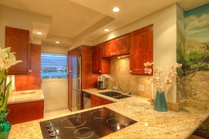 Fully equipped kitchen with cherry cabinets and granite countertops.
