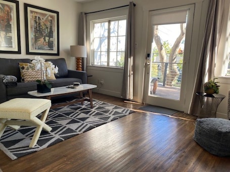 Sun-drenched living room off private front deck. Pull-out sofa and flat screen.