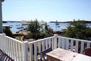 Expansive wrap-around deck overlooking harbor, w/ ample table & chair setting.