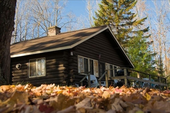 Deck has a charcoal grill and table with four chairs