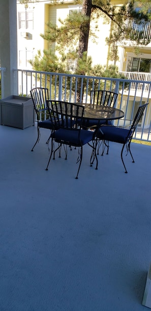 Wrought iron patio furniture with cushions.