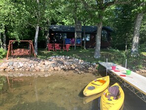 Lake side of the cabin. Beach area for the kids, swing and lakeside deck.