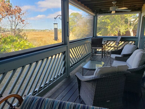 Comfortable screened seating to watch the wildlife on the marsh and the sunset. 