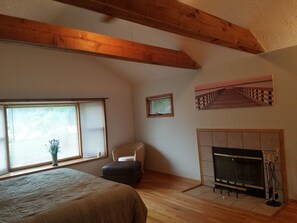 Master bedroom has king size bed with wood burning fireplace.