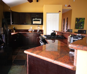 Well stocked custom kitchen with granite counters
