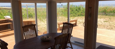 Sunroom with teak table and chairs for dining, entertaining, or game playing.