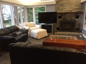 living room with 65 inch smart tv , leather furniture' wood burning fireplace 
