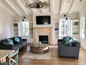 View of driftwood table/fireplace and custom shelving with gooseneck lighting 