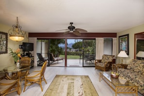 Spacious air-conditioned living room, lanai & lawn looks out to the ocean