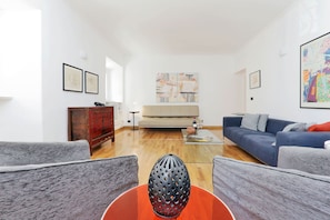 Spacious and elegant living room, with three windows for natural light.