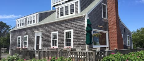 The house, showing widow's walk, large deck with two seating areas, gas grill