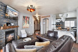 Living room with leather sectional with queen pullout bed.55 inchTV & fireplace