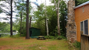 Backyard with lake, kayaks, paddle boat, picnic table.