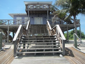 Close up view of the house showing decks surrounding the house and porches with ocean views.