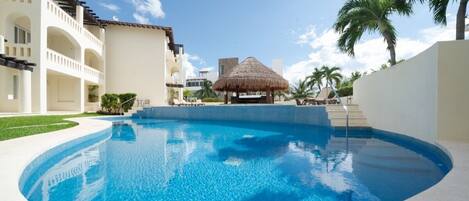 The Luna Maya common pool with lounge chairs and shaded palapa