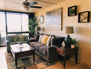 Living room with floor to ceiling windows for view of the ocean