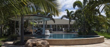 Looking back at the swimming pool, gazebo, and spa water fall in backround