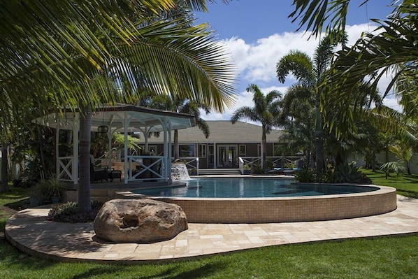 Looking back at the swimming pool, gazebo, and spa water fall in backround