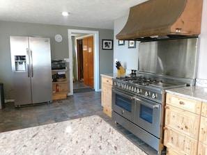 Upper kitchen - New 6 burner professional gas stove and refrigerator.