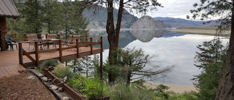 Cabin deck with view of lake and white stone rock