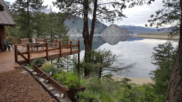 Cabin deck with view of lake and white stone rock