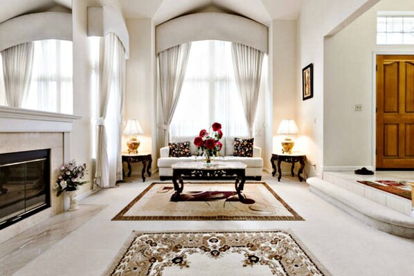 Stately living room with sofa, fireplace and piano