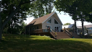 Front of cottage with huge deck and open stairway 