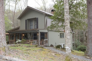 Side view of cabin. Gravel paths on each side take you down to private seating.