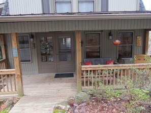 Ground level entry to front porch with  tin roof.  