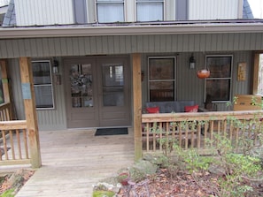 Ground level entry to front porch with tin roof.