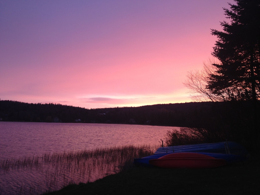 A pink and purple sunset over a Vermont lake as seen from the waterfront cottage