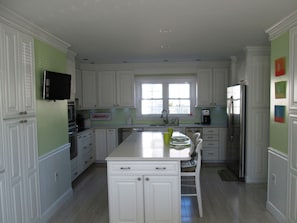 Updated kitchen with full fridge/freezer, oven, center island, and TV