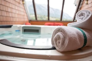 Private rooftop patio featuring a six-person hot tub and inviting living space, perfect for relaxation and enjoyment.