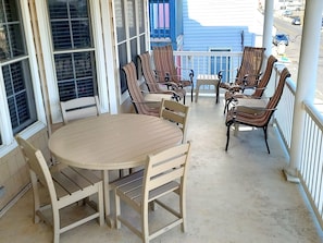 Nicely furnished covered porch with seating for 12 and partial ocean view