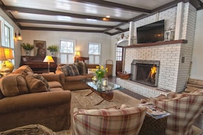 Main living room adjacent to kitchen with wood burning fireplace