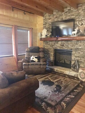 Open Living Room with floor to ceiling gas stone fireplace & 45" Roku TV w/cable