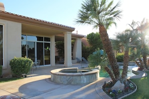 A rear view of the house and spacious patio with room for multiple sunbathers.