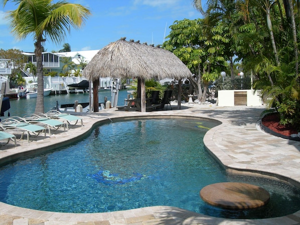 Heated pool with sitting area and Tiki.