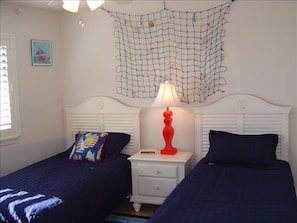 Cute bedroom with twin beds, nautical decor and plantation shutters