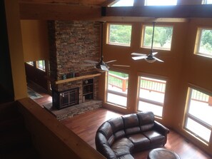 Loft bedroom overlooks living room with gas fireplace.