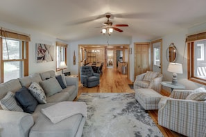 Living room is open to the kitchen/dining room with lakeside sunroom.