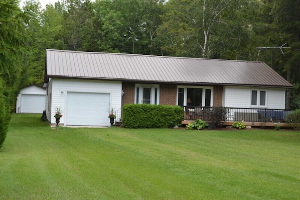 Front of the cottage includes large deck with seating area.